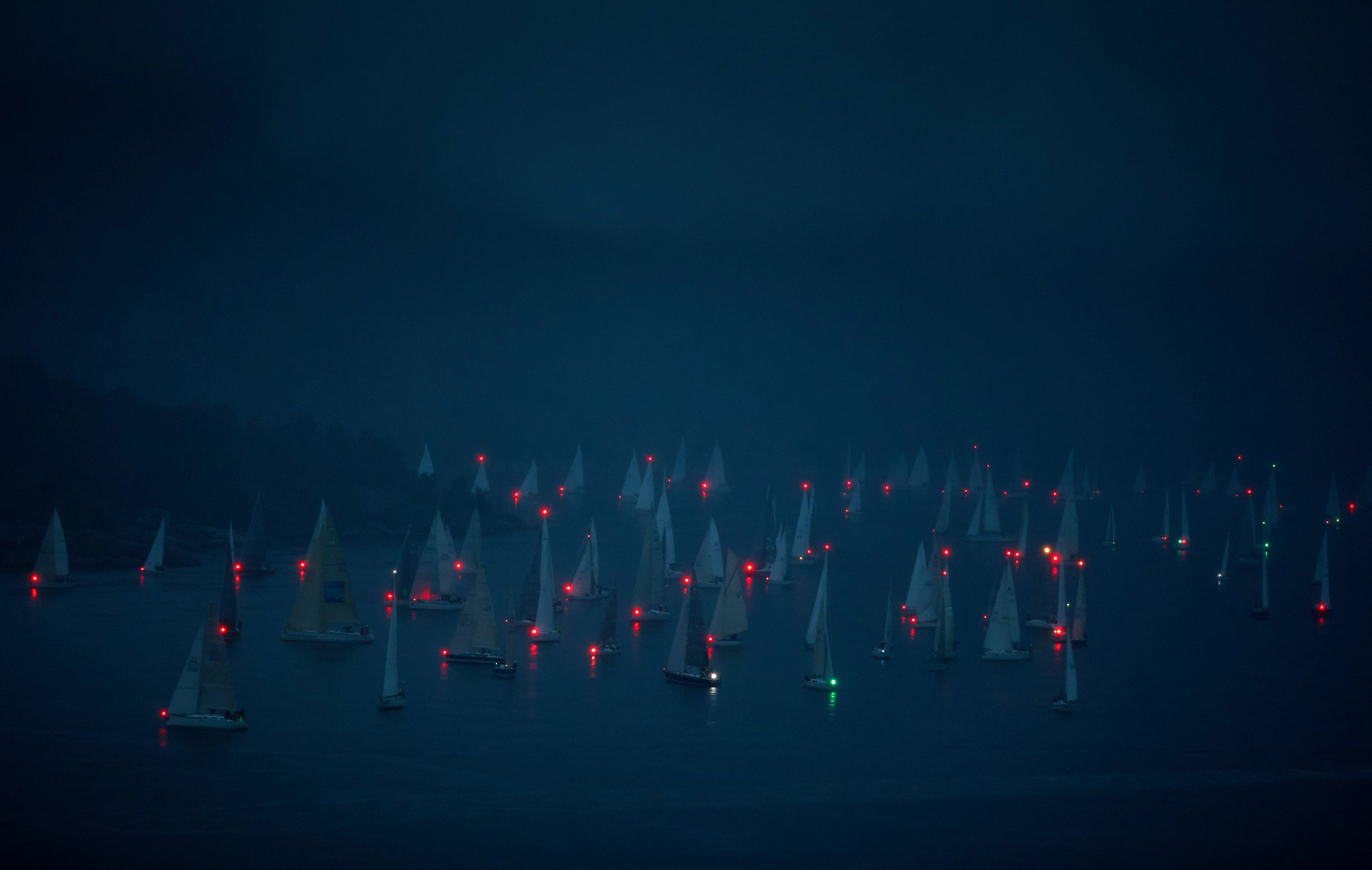 Progetto di brand identity per Tribù della Vela. La baia di notte con le luci di posizione delle barche a vela accese.